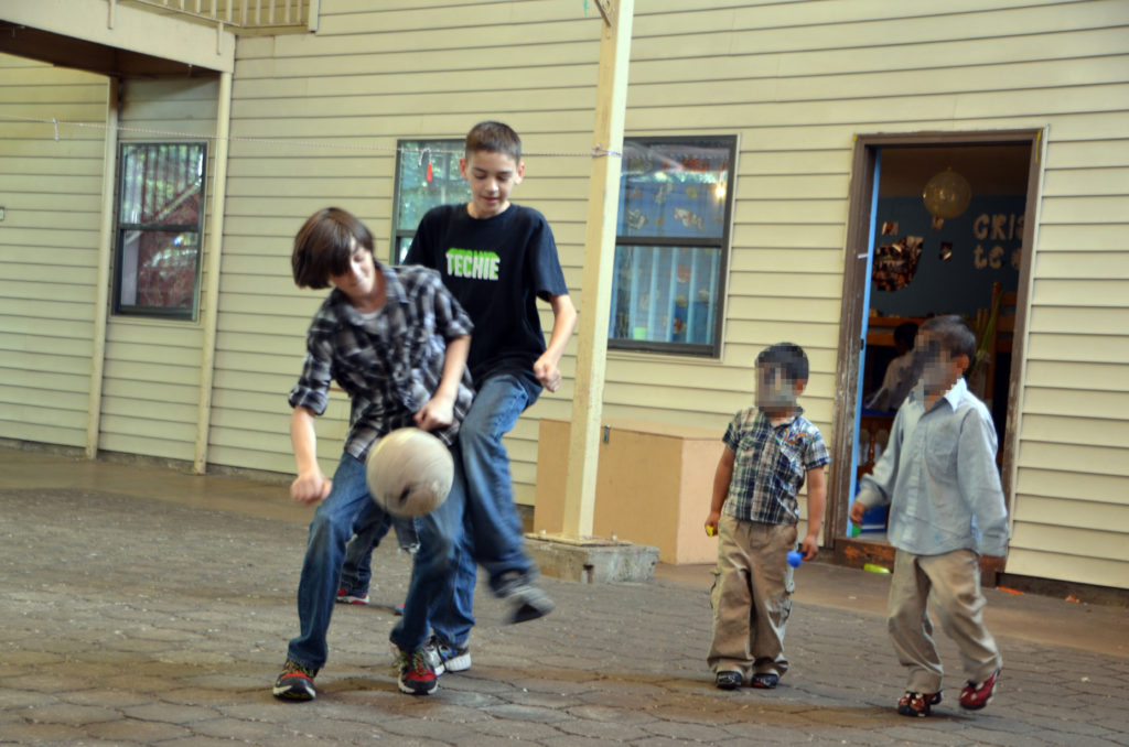 boys playing soccer at children's home blurred
